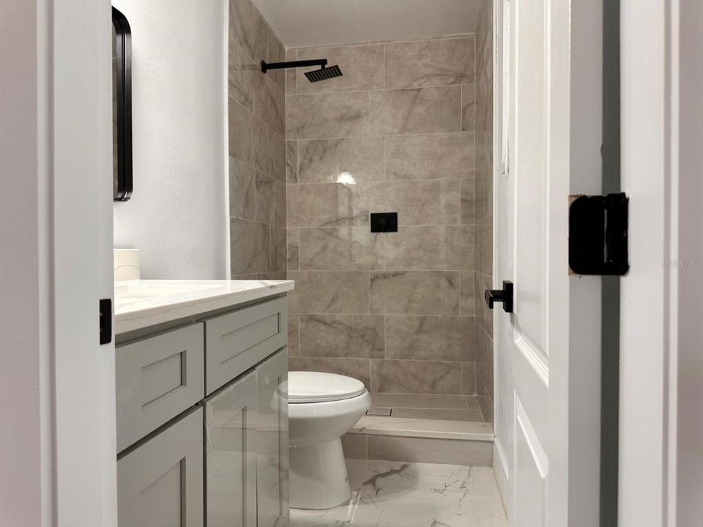 933 Windsor Street Lakeland, FL 33803 - Photo 31 of 47 a bathroom with a toilet a sink and shower