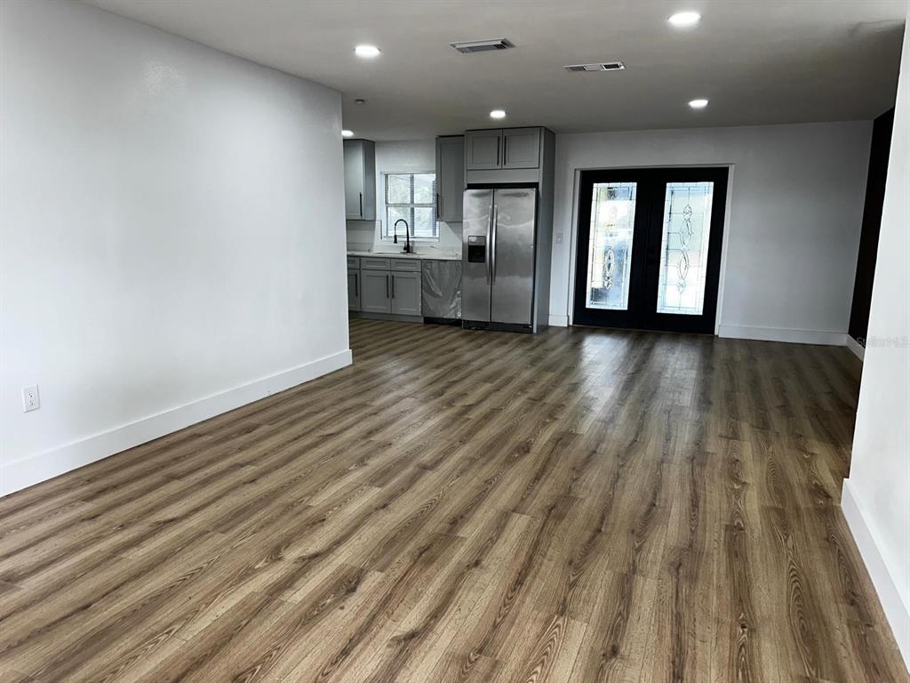 933 Windsor Street Lakeland, FL 33803 - Photo 7 of 47 a view of an empty room and kitchen with wooden floor