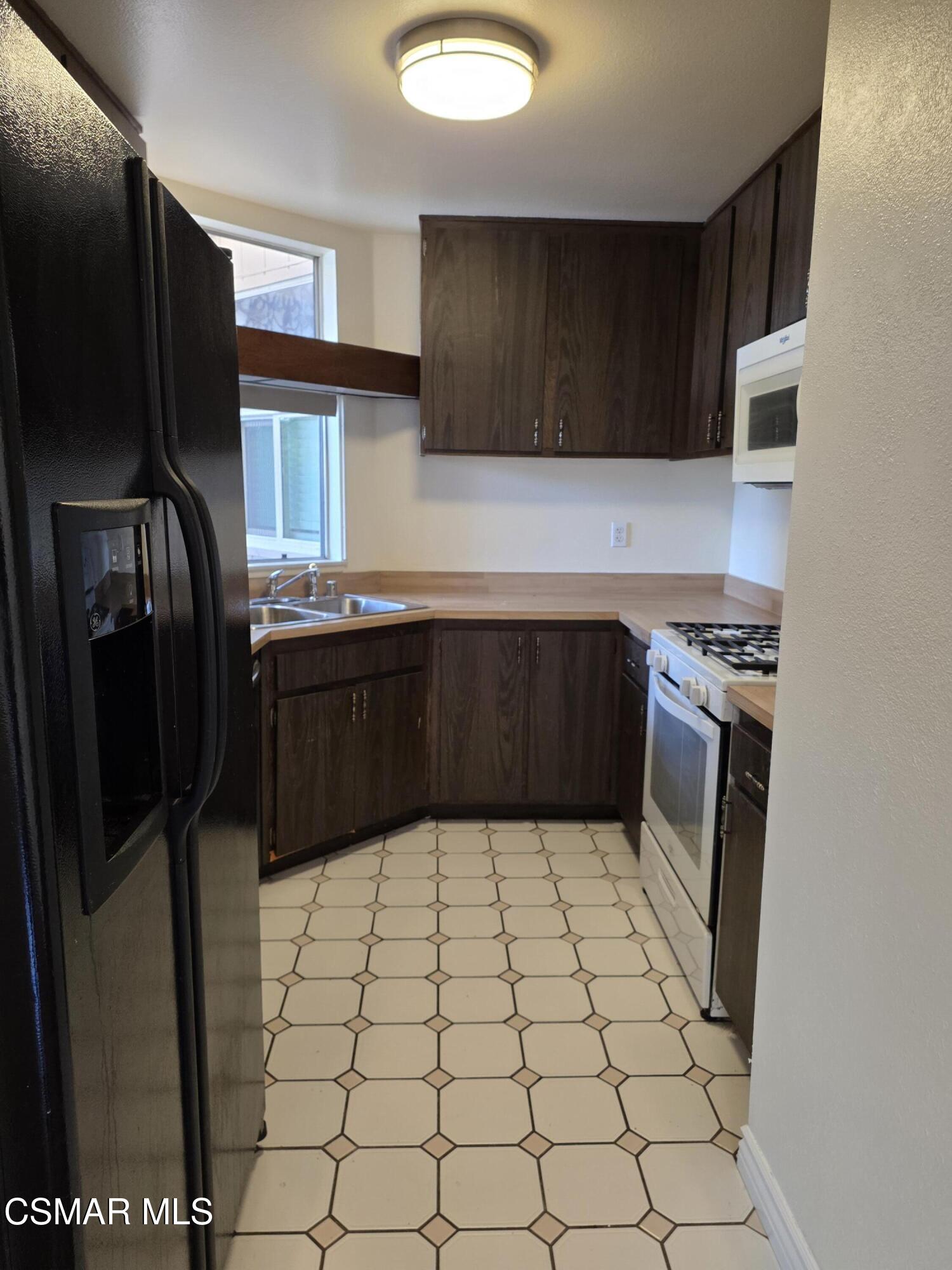 1778 Sinaloa Road, Unit 193 Simi Valley, CA 93065 - Photo 6 of 17 a kitchen with stainless steel appliances a refrigerator and a sink
