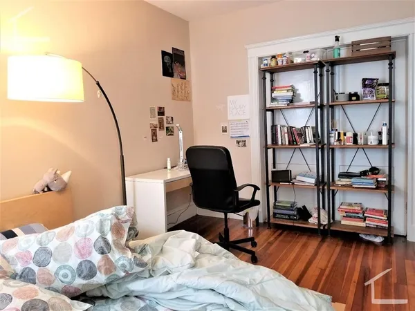 a bedroom with furniture and a book shelf
