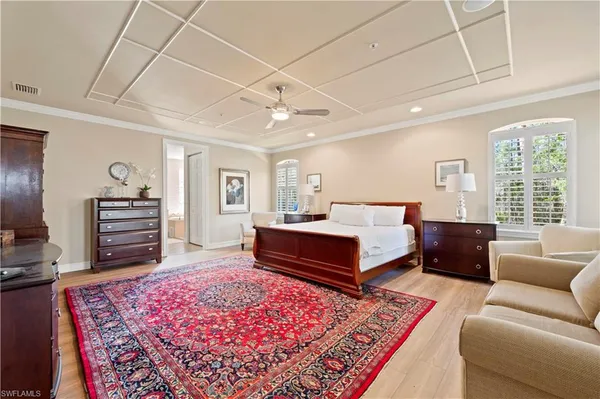 a spacious bedroom with a bed a couch and dresser