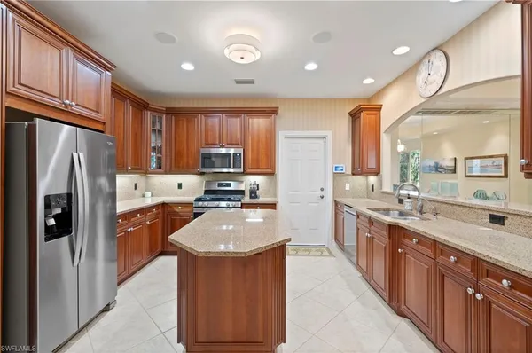 a kitchen with stainless steel appliances granite countertop refrigerator a sink a stove top oven and a refrigerator