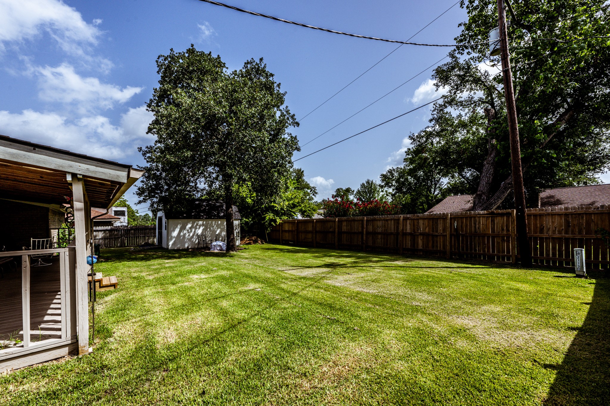 2115 Normal Park Drive Huntsville, TX 77340 - Photo 21 of 23 a view of a backyard with a small cabin and wooden fence