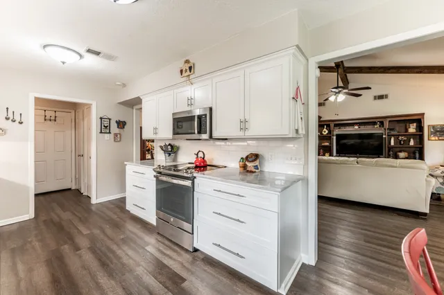 a kitchen with cabinets and wooden floor