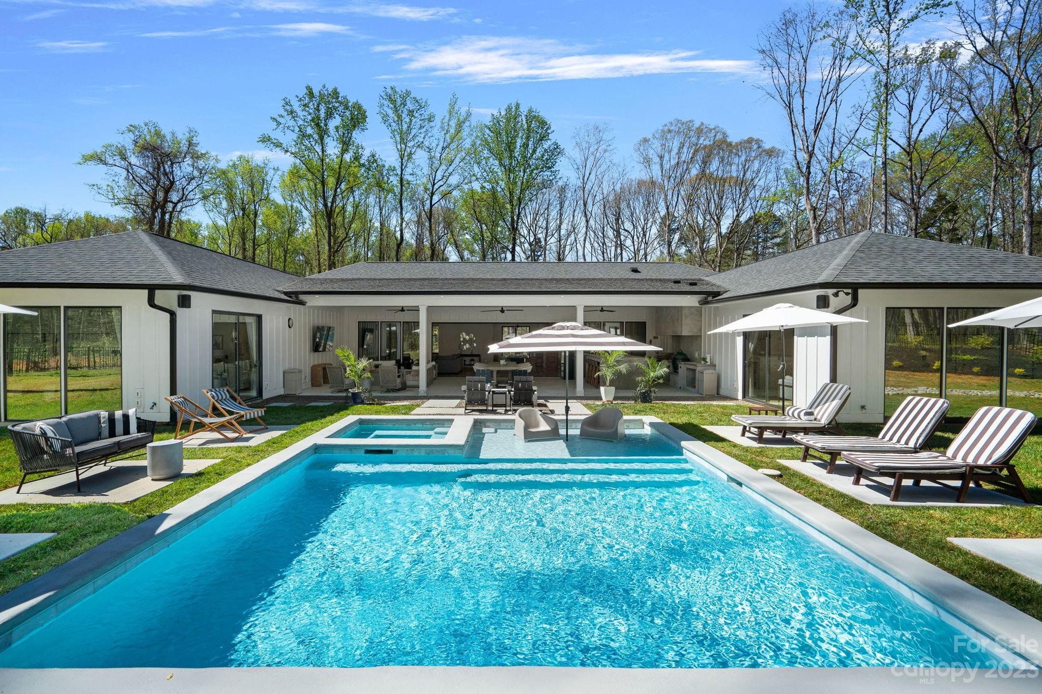 a view of a house with swimming pool and sitting area