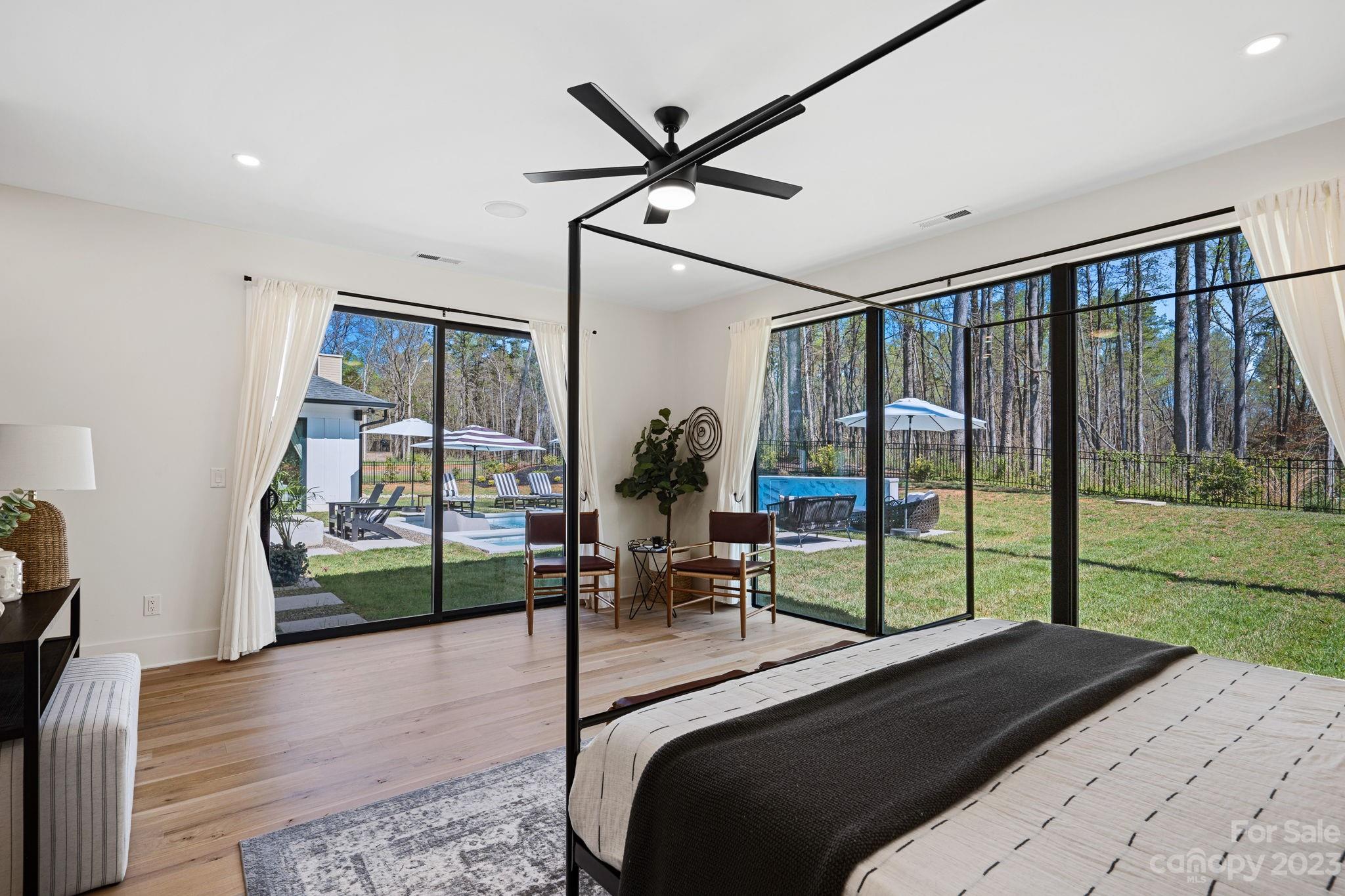 9622 Beatties Ford Road Huntersville, NC 28078 - Photo 35 of 48 a bedroom with a bed a large window with table and chairs