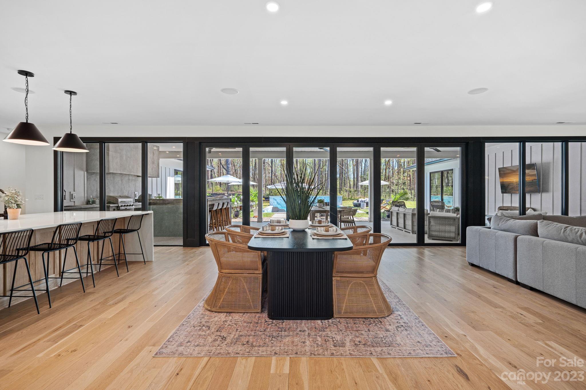 9622 Beatties Ford Road Huntersville, NC 28078 - Photo 5 of 48 a dining room with wooden floor and large windows