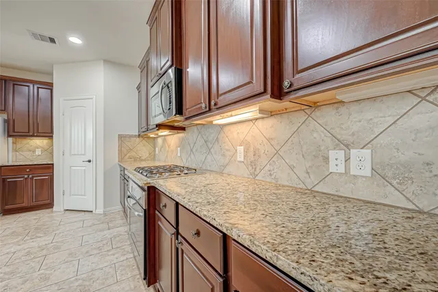 a kitchen with granite countertop a sink and cabinets