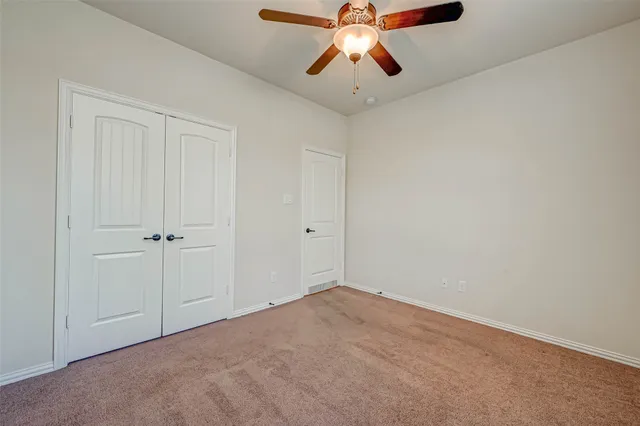 an empty room with chandelier fan