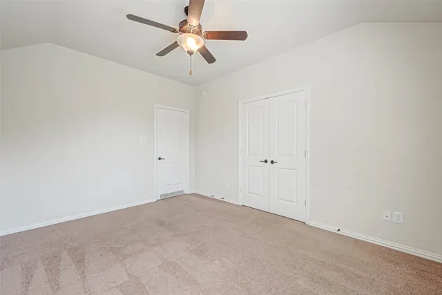 an empty room with a window and a fan