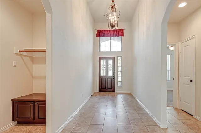 a view of a hallway with windows and chandelier