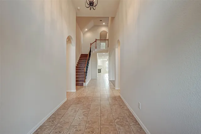a view of a hallway with wooden floor and a bathroom