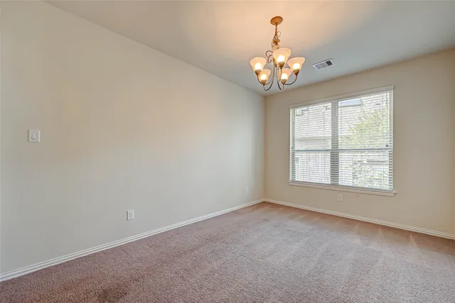an empty room with chandelier curtains and large windows
