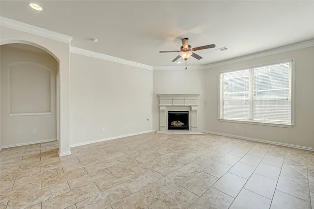 an empty room with windows and fireplace