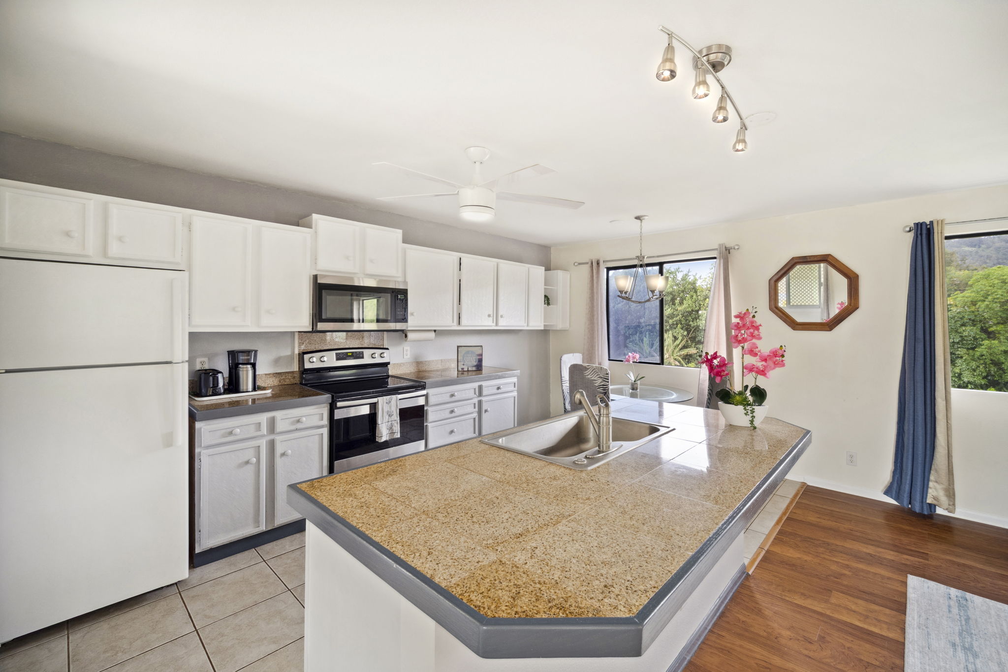 4439 Punee Road Koloa, HI 96756 - Photo 2 of 30 a kitchen with stainless steel appliances granite countertop a refrigerator sink stove microwave and cabinets