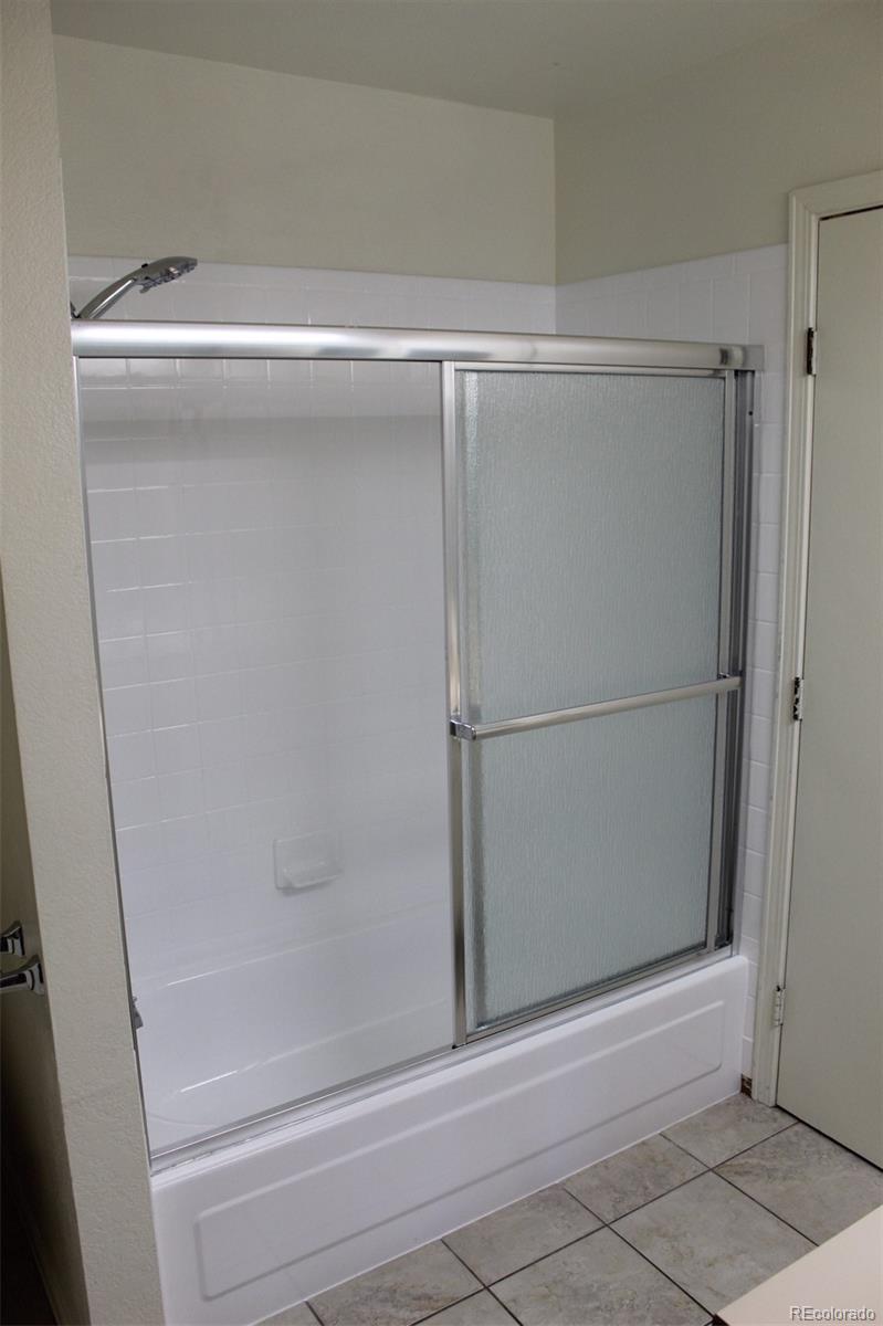 138 48th Avenue Greeley, CO 80634 - Photo 13 of 29 a bathroom with a glass shower door