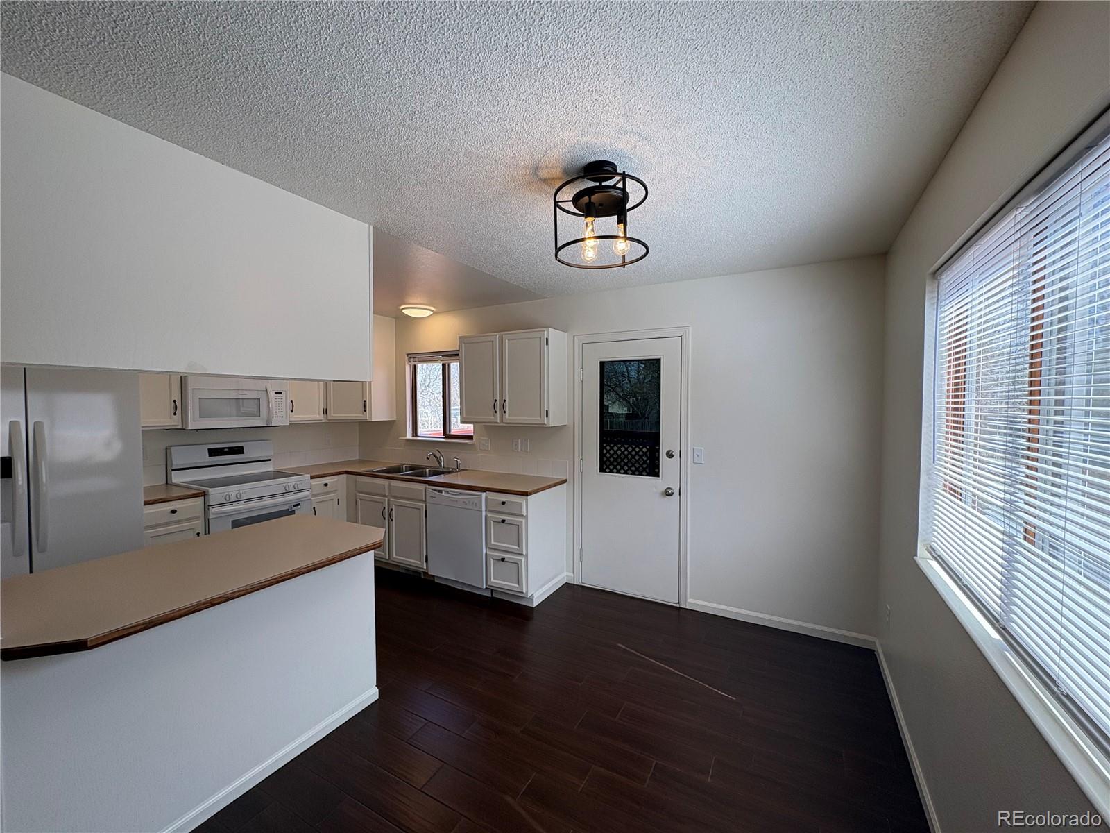 138 48th Avenue Greeley, CO 80634 - Photo 3 of 29 a kitchen with a refrigerator and a stove top oven