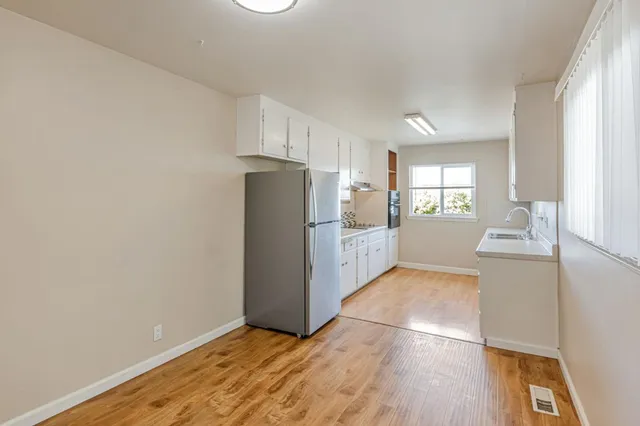 a view of empty room with wooden floor