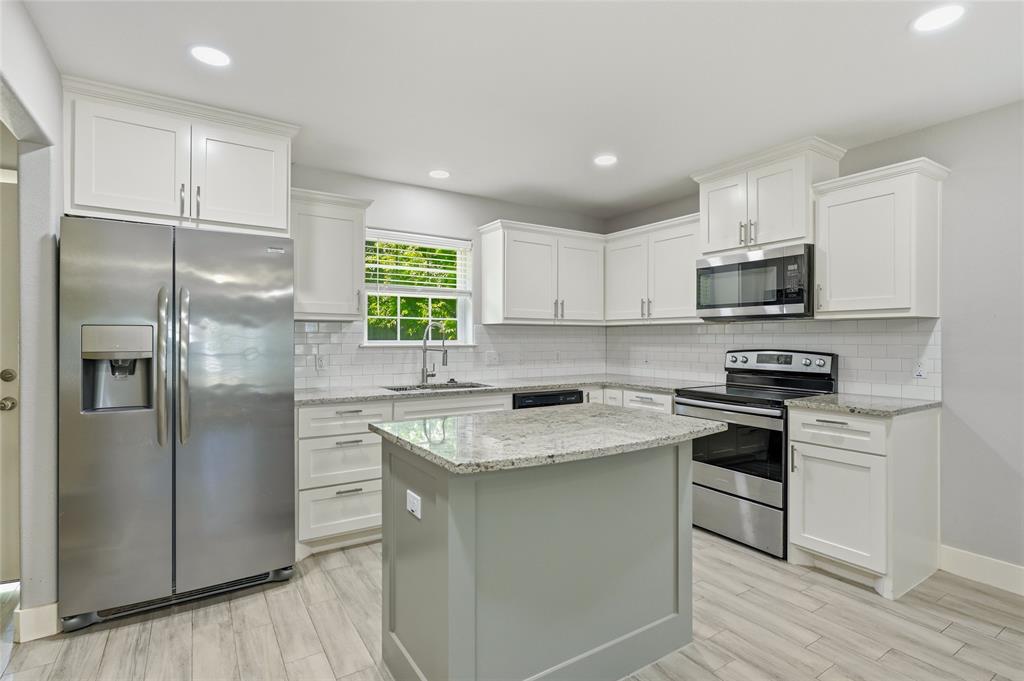 318 Munson Street Denison, TX 75021 - Photo 6 of 21 a kitchen with stainless steel appliances granite countertop a stove a refrigerator and a sink