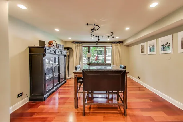 a dining room with stainless steel appliances kitchen island granite countertop a table chairs and a refrigerator