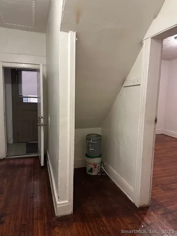 a view of a hallway with wooden floor and closet