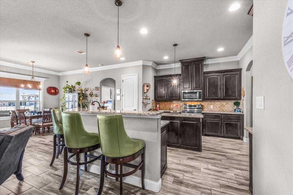 139 Stanford Lane Springtown, TX 76082 - Photo 11 of 36 Open-concept kitchen with large breakfast bar and pendant lighting