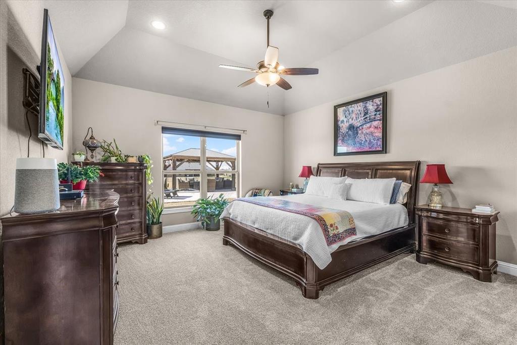 139 Stanford Lane Springtown, TX 76082 - Photo 15 of 36 Primary bedroom with natural light, vaulted ceilings, a ceiling fan, recessed lighting and new carpet.