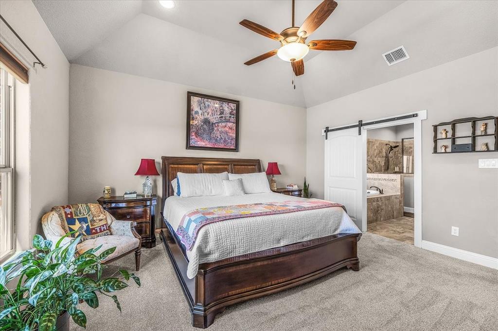 139 Stanford Lane Springtown, TX 76082 - Photo 16 of 36 Primary bedroom featuring sliding barn door to bathroom