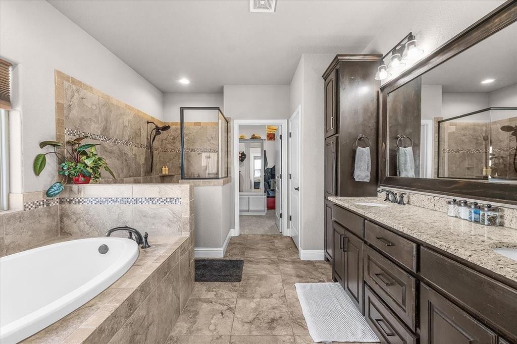 139 Stanford Lane Springtown, TX 76082 - Photo 17 of 36 Primary bathroom featuring double vanity, granite countertop, and built-in cabinets
