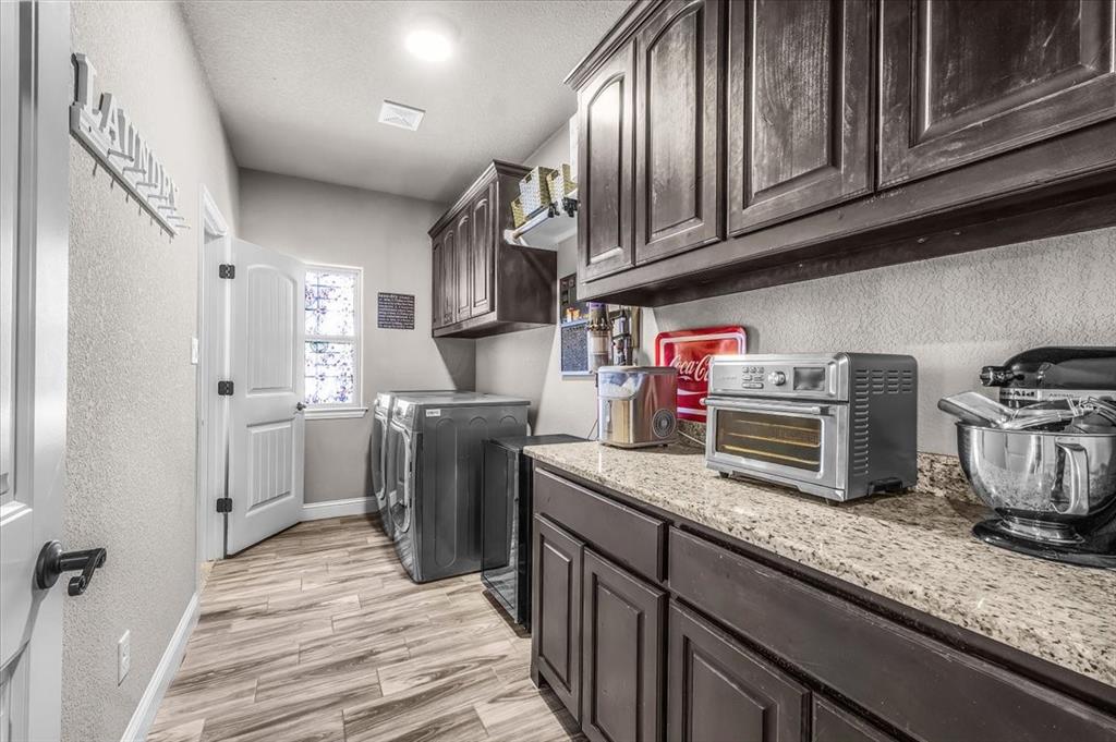 139 Stanford Lane Springtown, TX 76082 - Photo 25 of 36 Large utility room featuring built-in cabinets and granite countertops. Plenty of room to add an additional freezer or refrigerator.