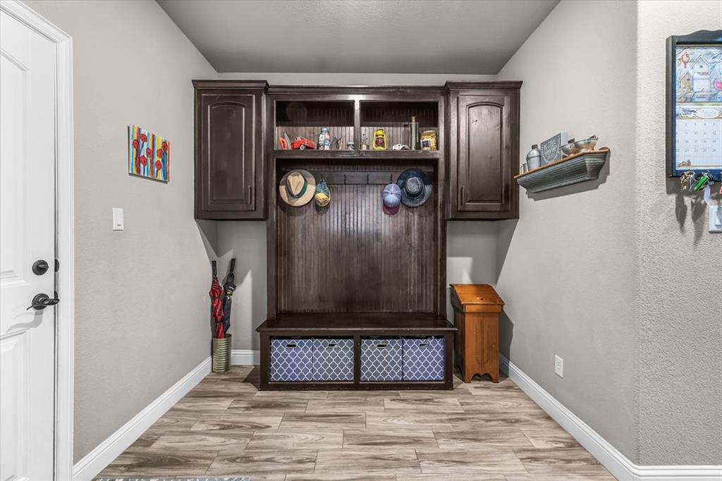 139 Stanford Lane Springtown, TX 76082 - Photo 26 of 36 Functional mudroom featuring wood built-in cabinets overhead storage and wall hooks with built-in bench and storage cubbies.