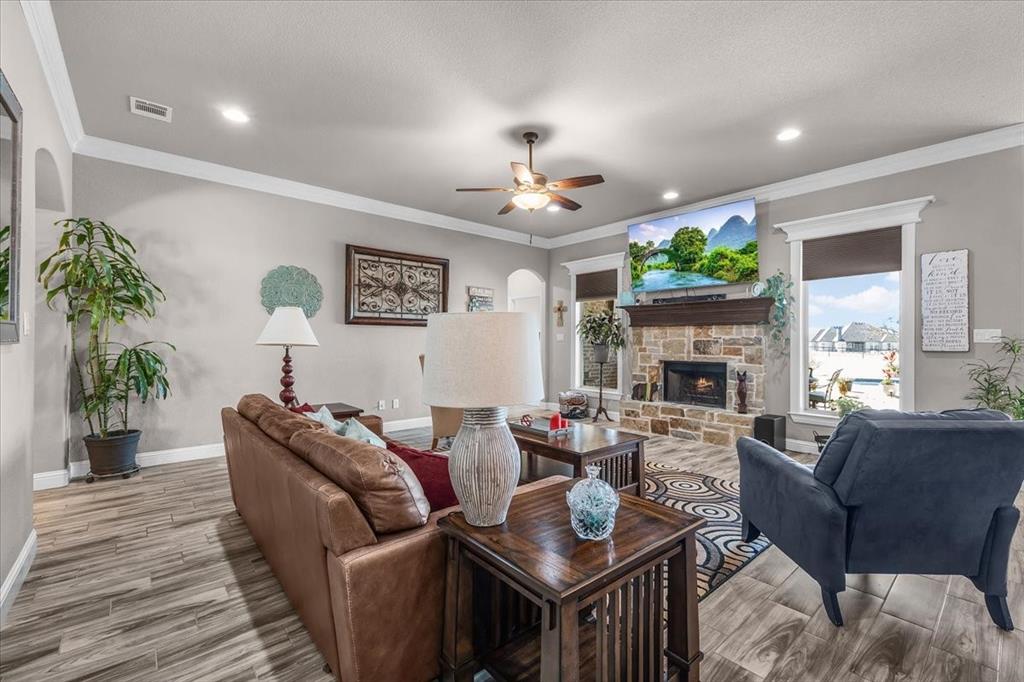 139 Stanford Lane Springtown, TX 76082 - Photo 5 of 36 Living area featuring views of the backyard and stone fireplace with stained mantle.