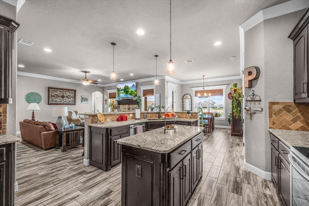 139 Stanford Lane Springtown, TX 76082 - Photo 6 of 36 Kitchen featuring island and granite countertops and stone backsplash