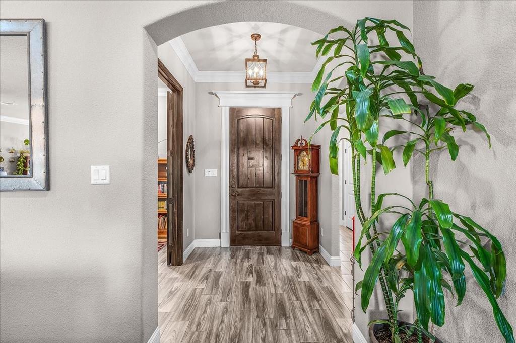 139 Stanford Lane Springtown, TX 76082 - Photo 7 of 36 Entrance foyer with arched walkways, crown molding, stained front door and chandelier.