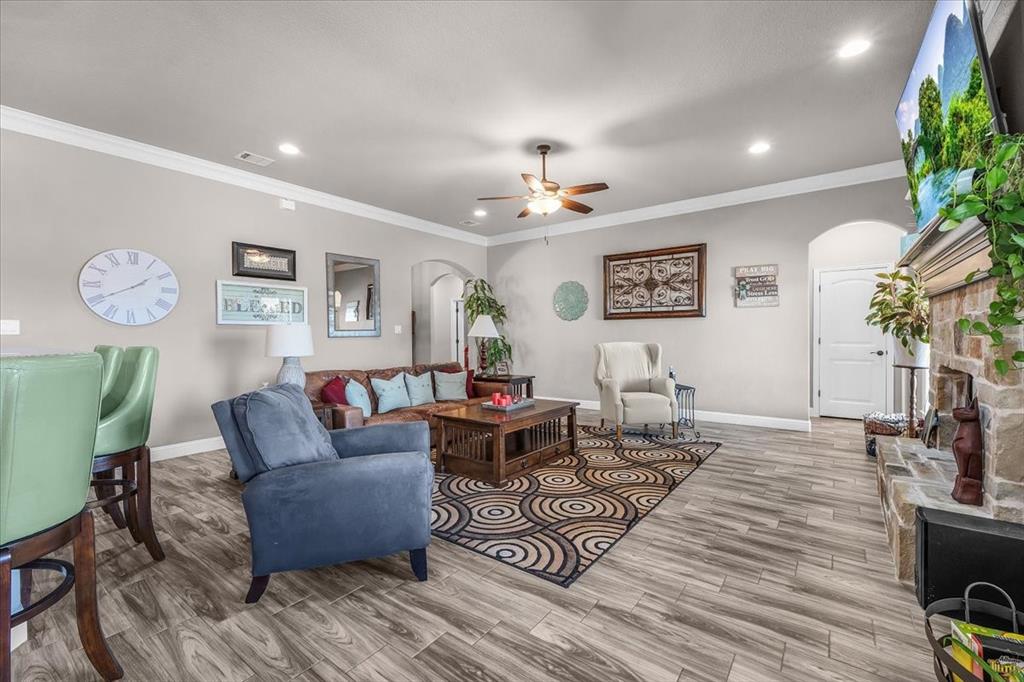 139 Stanford Lane Springtown, TX 76082 - Photo 9 of 36 Living area featuring ceiling fan, wood tiled floors, arched walkways, plenty of natural light, and crown molding