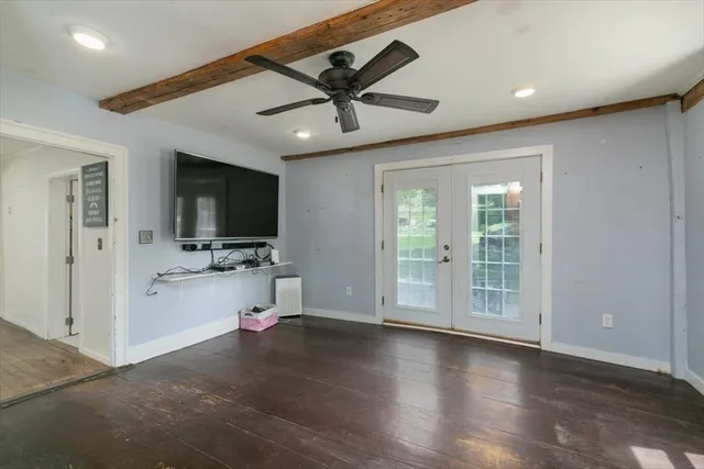 a view of a livingroom with a flat screen tv wooden floor and a ceiling fan