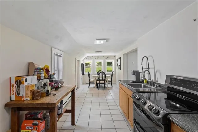 a kitchen with stainless steel appliances granite countertop a stove and a dining table
