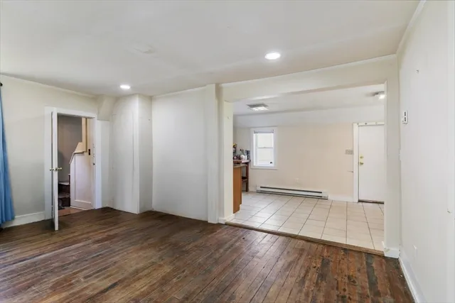 an empty room with wooden floor & windows and bathroom
