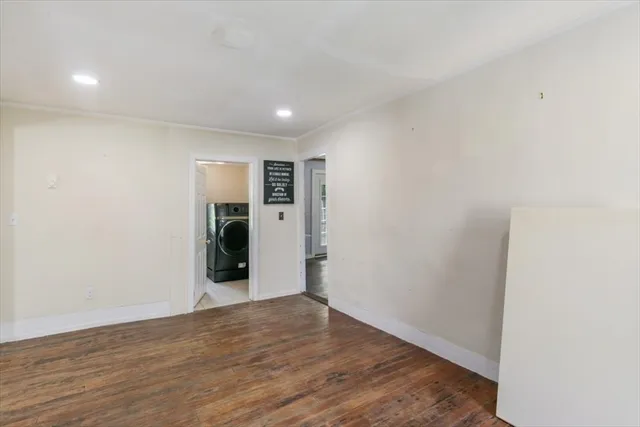 a view of an empty room with wooden floor and closet