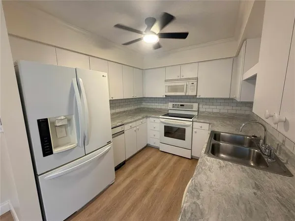 a kitchen with white cabinets and stainless steel appliances