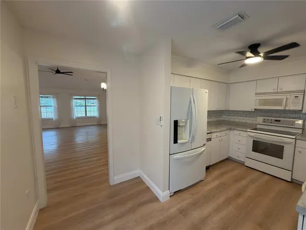 a kitchen with white cabinets and stainless steel appliances