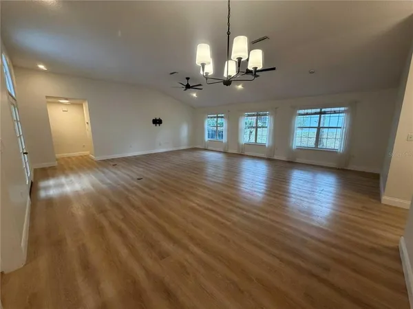 a view of a room with chandelier fan and wooden floor