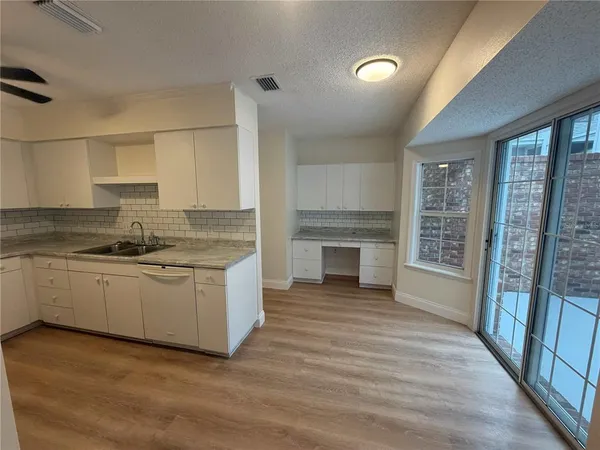 a large kitchen with granite countertop a stove top oven a sink a counter space and cabinets