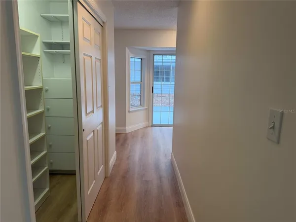 a view of a hallway with wooden floor and closet