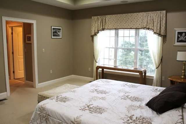a bedroom with a large bed and a window