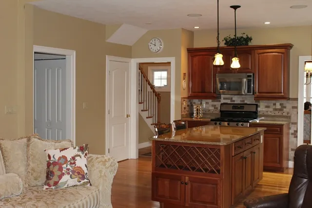 a kitchen with kitchen island granite countertop a stove top oven a sink a dining table and chairs