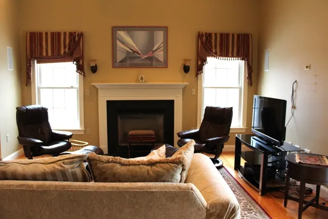 a living room with furniture a flat screen tv and a fireplace