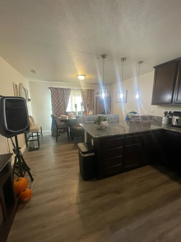 a kitchen with stainless steel appliances granite countertop a stove a sink dishwasher and a flat screen tv