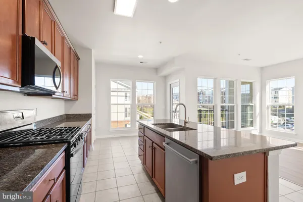 a kitchen with granite countertop a sink and a stove