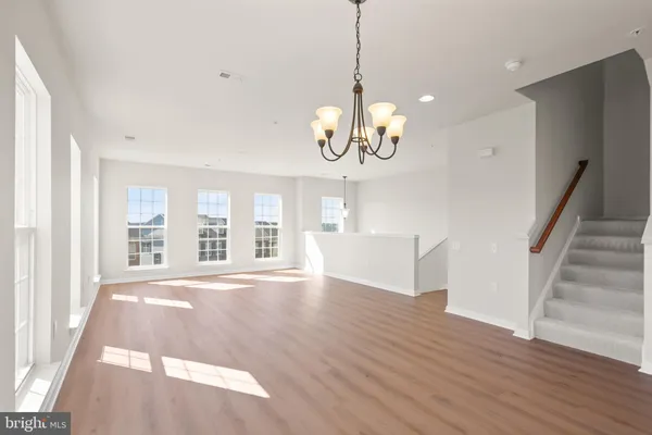 a view of an empty room with wooden floor and windows